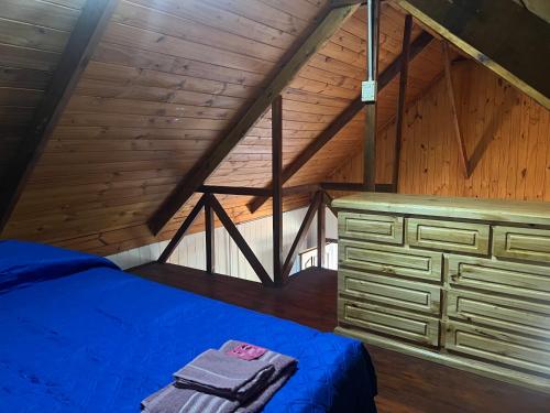 a bedroom with a blue bed and a wooden ceiling at Cabaña, Sol y Paz in Lima