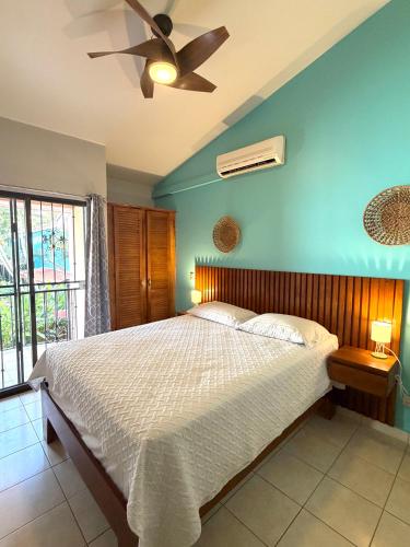 a bedroom with a bed and a ceiling fan at Happy Oasis Second Floor Condo with Terrace in Coco