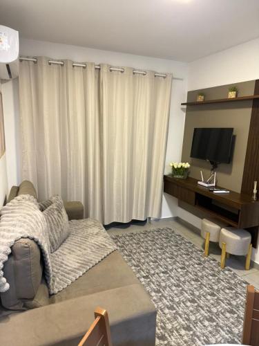 a living room with a couch and a flat screen tv at Park Cowboy - Valentina in João Pessoa