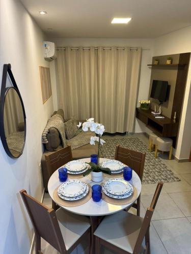 a living room with a table with plates and chairs at Park Cowboy - Valentina in João Pessoa
