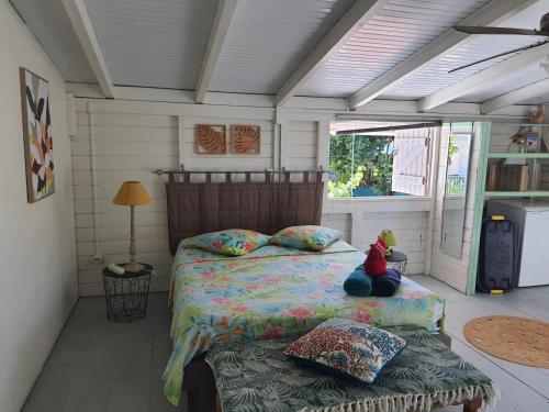 een slaapkamer met een bed met een teddybeer erop bij Appartement cosy au Carbet avec balcon et vue sur mer - 70 m² in Le Carbet