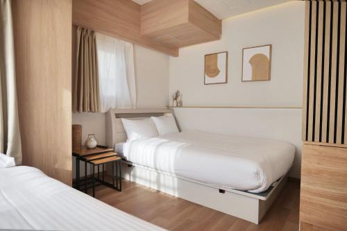 a hotel room with two beds and a window at Petit Grande Nuage in Tokyo