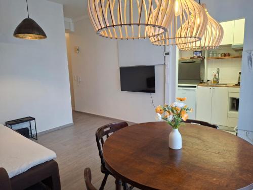 a dining room with a table with a vase of flowers at Roosevelt Apartment Antwerp in Antwerp
