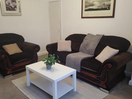 a living room with two couches and a table at Modern North Shields Home - Perfect for Short or Long Stays in Newcastle upon Tyne