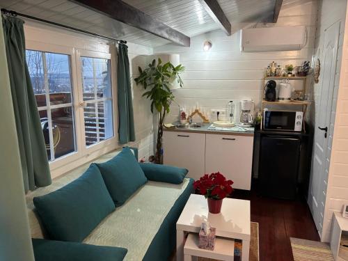 een woonkamer met een blauwe bank en een keuken bij Mika Tiny House in Daia