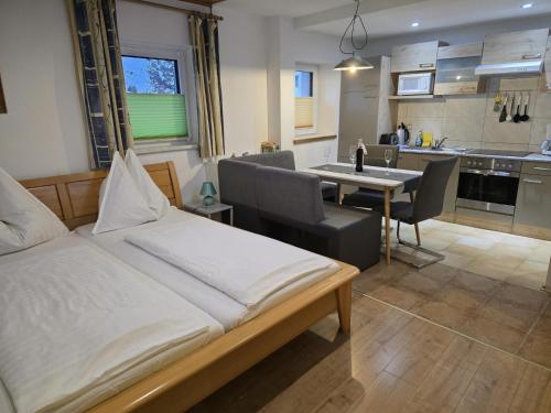 een slaapkamer met een bed en een tafel en een keuken bij Schloßblick in Ramingstein