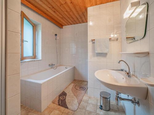 een badkamer met een bad en een wastafel en een ligbad bij Kitzsteinhorn in Kaprun