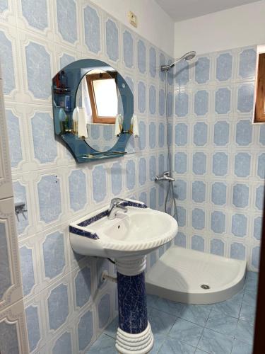 a blue and white bathroom with a sink and a mirror at Sweet home Leskovik in Leskovik