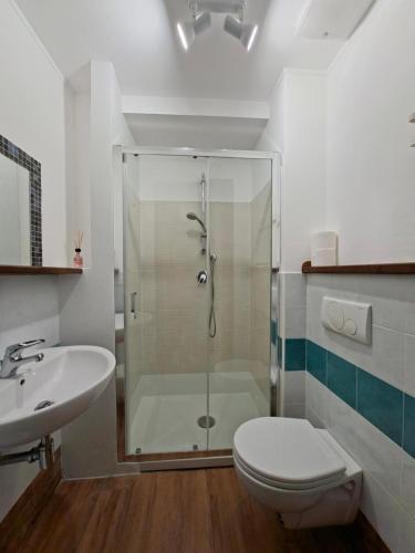 een badkamer met een douche, een toilet en een wastafel bij Casa del Sole Guest House in Alghero