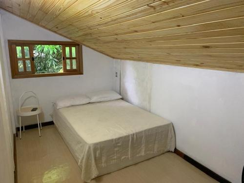 een kleine slaapkamer met een bed en een raam bij Casa Saquarema Jaconé com Piscina, 4Q in Saquarema