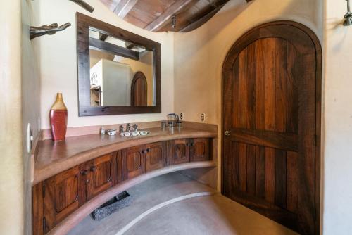 un bagno con un lavandino in legno e uno specchio di Casa de la Costa a Troncones