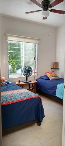 a bedroom with two beds and a ceiling fan at Casa Adhita, tú confort es nuestra prioridad. in Yautepec de Zaragoza