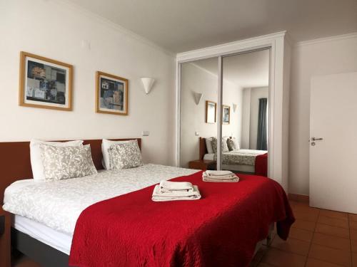 a bedroom with a bed with a red blanket at Vila Apostol in Lagos