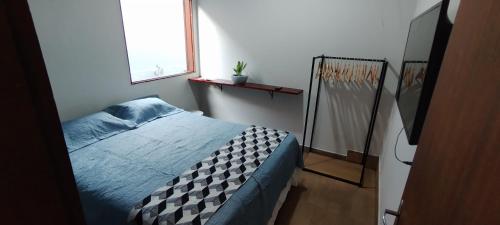 a bedroom with a bed and a window at Doce lar in Búzios