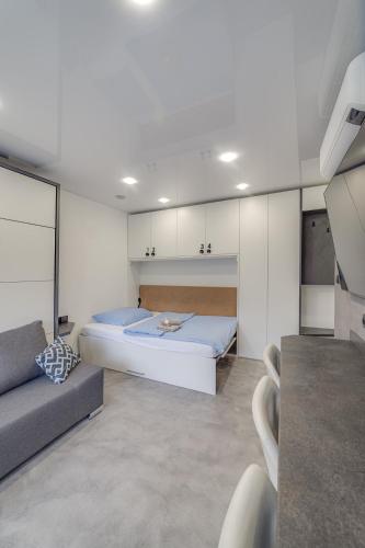 a bedroom with a large bed and a couch at AR Rezidencia Rosná in Košice