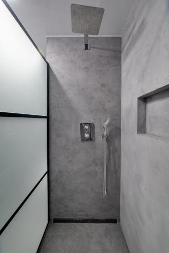a bathroom with a shower in a concrete wall at AR Rezidencia Rosná in Košice