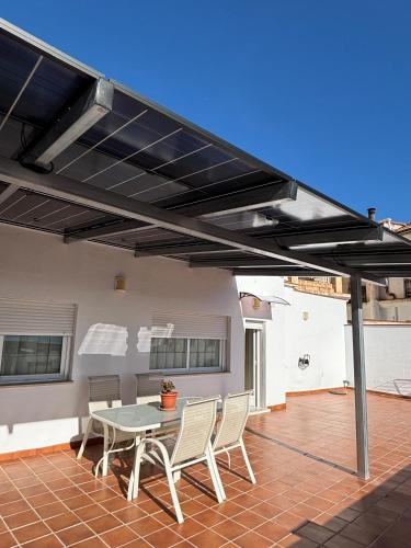 a patio with a table and chairs under awning at Apartamento vital centrico in Lanjarón