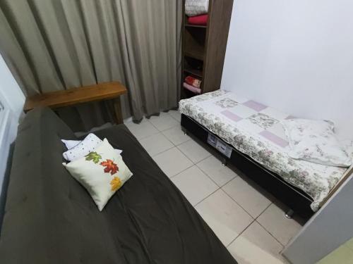 een kleine slaapkamer met 2 bedden en een tafel bij Loft conceito aberto - 4 pessoas in Araranguá