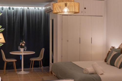 a bedroom with a bed and a table with chairs at Increíble estudio boutique con vista al mar Mediterráneo in Benalmádena