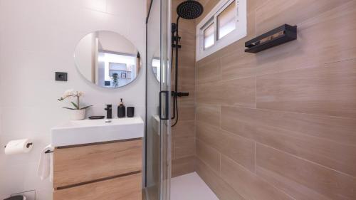 a bathroom with a shower with a sink and a mirror at Increíble estudio boutique con vista al mar Mediterráneo in Benalmádena