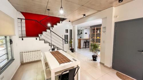 a living room with a white table and a red wall at Casa Bouchard in Valeria del Mar