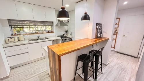 a kitchen with white cabinets and a wooden counter top at Casa Bouchard in Valeria del Mar