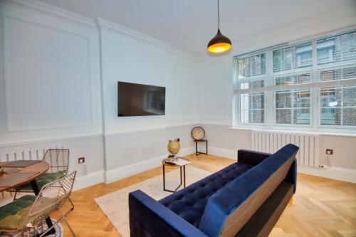 a living room with a blue couch and a table at RoyalPark Apartments in London