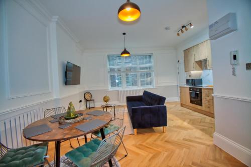 a living room with a table and a kitchen at RoyalPark Apartments in London