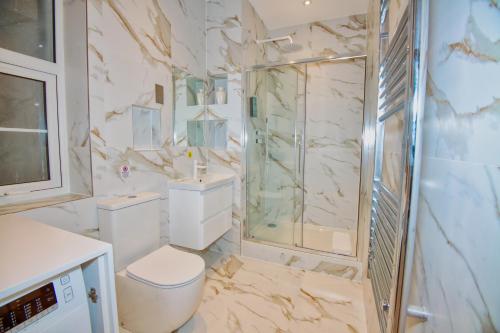 a white bathroom with a shower and a toilet at RoyalPark Apartments in London