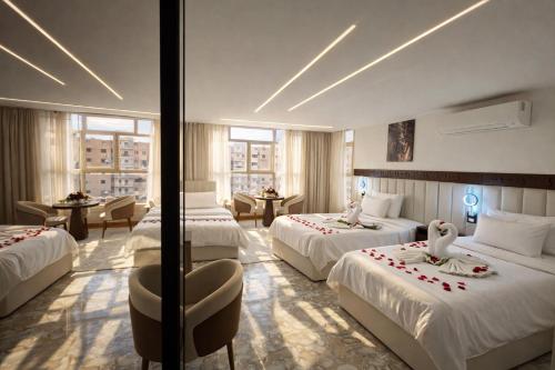 a hotel room with three beds with swans on them at Lotus signature hotel in Cairo