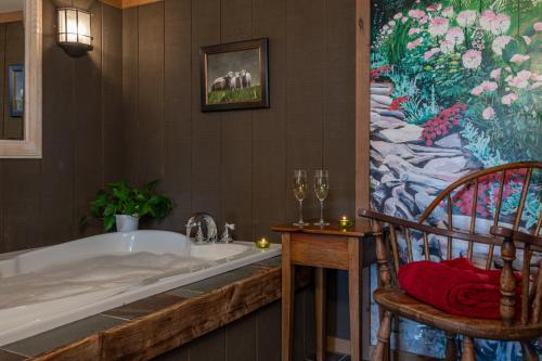 eine Badewanne in einem Badezimmer mit einem Gemälde an der Wand in der Unterkunft Deerhill Inn in West Dover