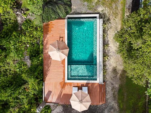 an overhead view of a swimming pool with umbrellas at Uzuri Kubo Huts & Kwartos in Moalboal