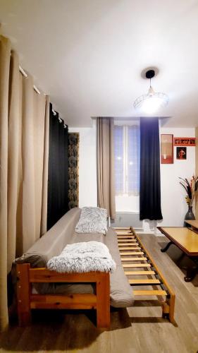 a room with two beds and a table in it at Apparemment Nawé in Tarbes