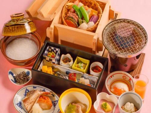 una tavola con scatola di alimenti e piatti di Tsukino Yado Sara a Hakone