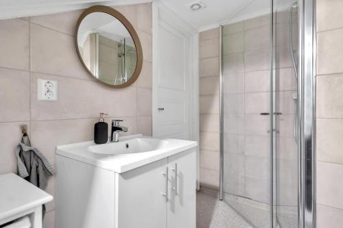 a white bathroom with a sink and a shower at Oddernesveien 7 in Kristiansand