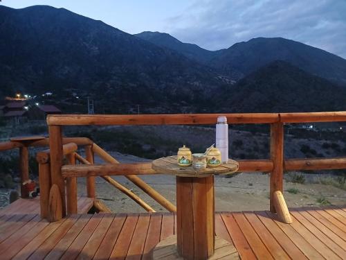 un tavolo su un ponte con una bottiglia di vino di Cabaña Rincón del Aarón a Ciudad Lujan de Cuyo