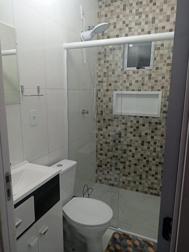 a bathroom with a toilet and a glass shower at Studio Campeche in Florianópolis