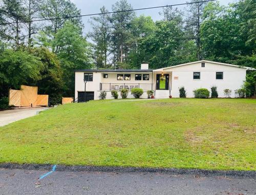 een wit huis met een grote tuin ervoor bij Southern Pines Gem with 2 Master-King Suites in Southern Pines