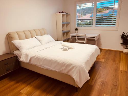 a bedroom with a bed with a desk and a window at Carindale family home, private pool, leisure accommodation in Brisbane