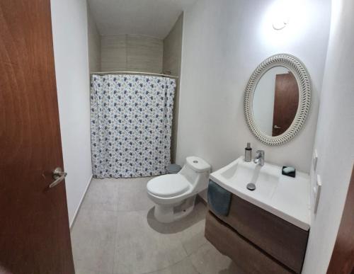 a bathroom with a toilet and a sink and a mirror at casa estefania in San Carlos