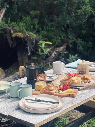 un tavolo di legno con piatti di cibo sopra di Koywe Refugio a Puerto Varas