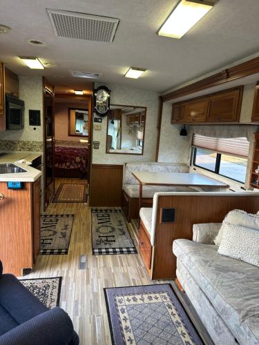 a living room with a couch and a kitchen in a bus at Comfortable and cozy RV in Lehigh Acres