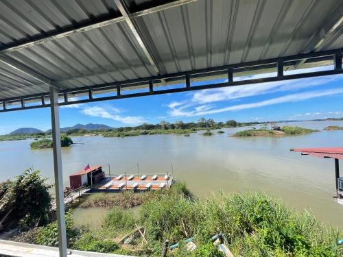 een rivier met een boot in het water bij Tena Guest House in Don Det