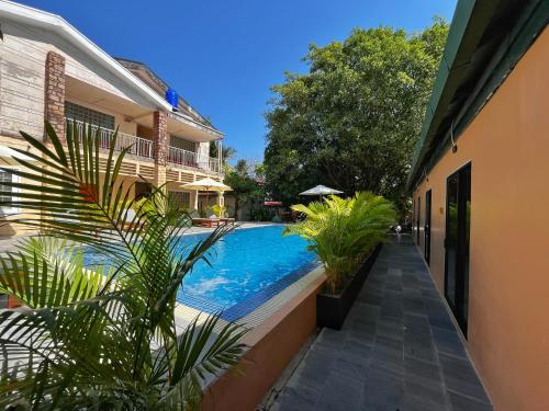a swimming pool with plants next to a building at Monkey Republic Kampot in Kampot