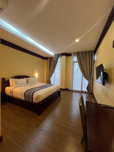 a hotel room with a bed and a television in it at Pon Arena Hotel in Muang Không