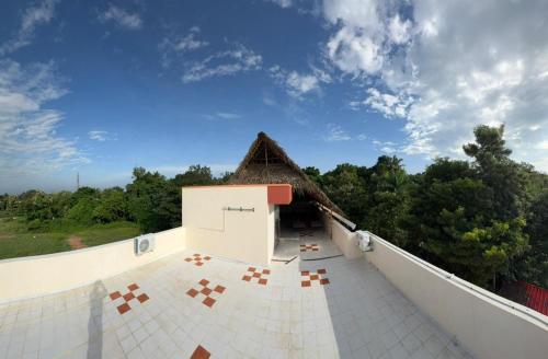 a view of a building with a thatch roof at Healing Home Unity Thilo Guest House in Puducherry