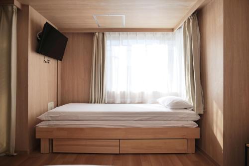 a small bedroom with a bed with a window at Petit Grande Nuage in Tokyo