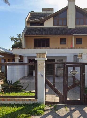 a gate in front of a house with a fence at Sobrado em Imbé - RS in Imbé