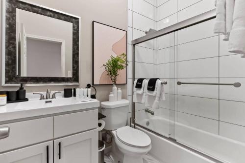 a bathroom with a toilet and a glass shower at The Bricklight | Elevated 3BR + Parking in Soulard in Saint Louis