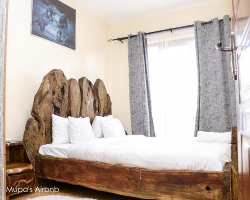 a bedroom with a bed made out of logs at Mupa Luxury Condo IV BnB in Nyahururu